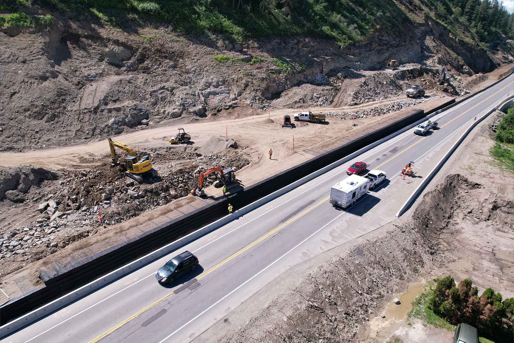 Arial view of Highway 1 expansion work site next to existing highway with traffic